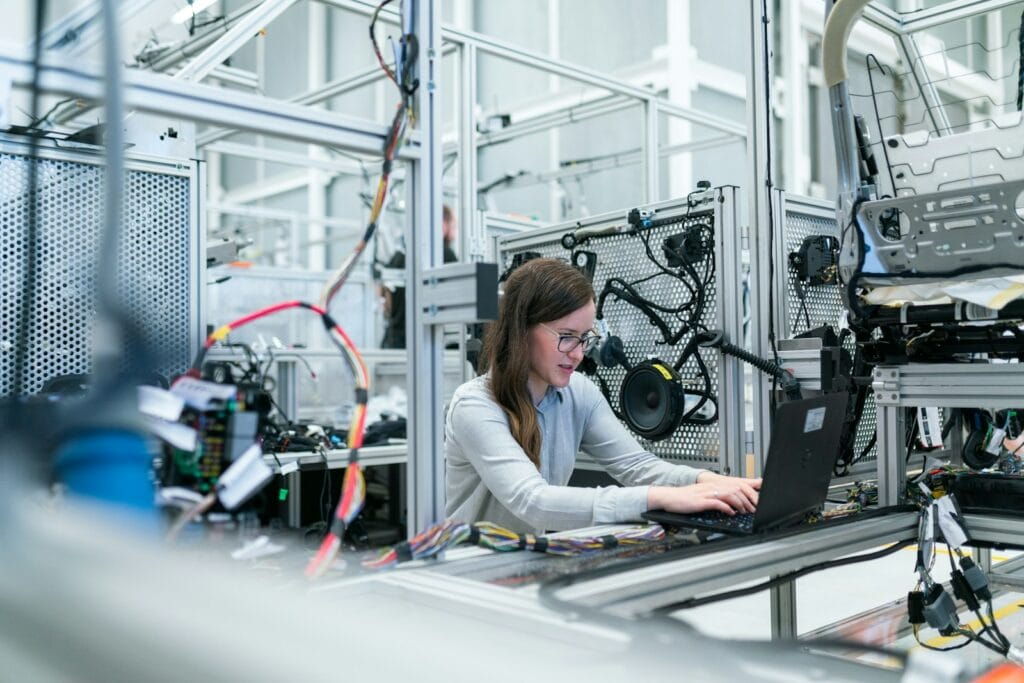 Reliability engineer reviewing periodic vibration route readings and online machine health trends in an Indonesian industrial control room
